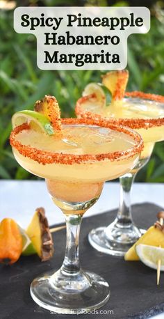 spicy pineapple habanero margarita is served in coupe glasses with garnishes