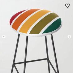 a stool with a multi - colored seat cover on it's back and legs