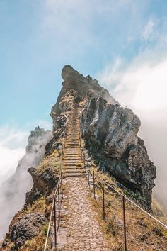 stairs leading up to the top of a mountain with fog in the air behind them