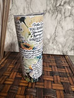 a tumbler cup sitting on top of a wooden table next to a marble wall