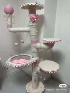 a cat tree that is made out of some kind of thing with balls and bows on it