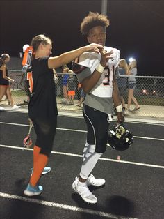 two young people standing on a football field