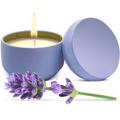 a candle with a flower next to it on a white surface and purple tins