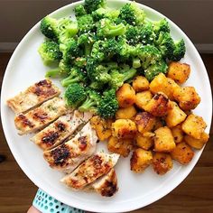 a white plate topped with chicken, broccoli and potatoes