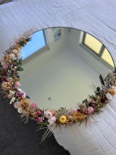 a mirror that has some flowers on it in the shape of a heart shaped frame