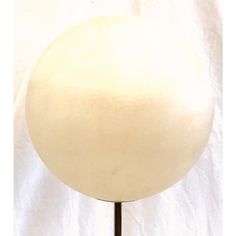 a white ball sitting on top of a metal stand