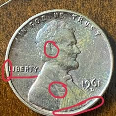 a close up of a coin with red marker marks on the front and back of it