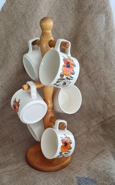 a wooden stand with cups and saucers on top of it, in the shape of a tree