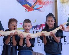 four children holding a large snake in their hands