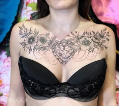 a woman wearing a black bra with flowers on her chest