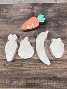 three wooden fruits and vegetables sitting on top of a wooden table