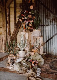 an arrangement of flowers and cacti is displayed on the floor