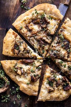 a pizza cut into eight slices on top of a wooden cutting board next to mushrooms and herbs