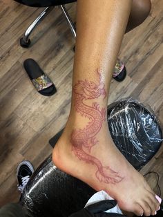 a woman's foot with a dragon tattoo on her left leg and the words, tweete su reposta