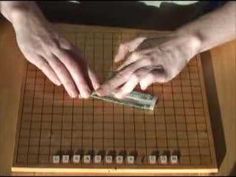 two hands reaching for money on a board game