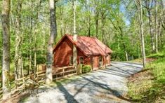 a red cabin sits in the middle of a wooded area