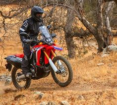 a man riding on the back of a red dirt bike