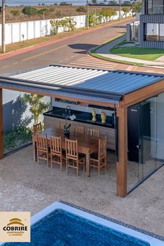 an outdoor dining area next to a swimming pool with a table and chairs on it