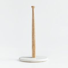 a wooden toothbrush holder on a white surface with a wood stick sticking out of it