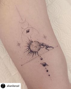 a woman's thigh with an image of the sun and planets on it in black ink