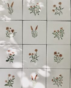 nine tiles with flowers painted on them