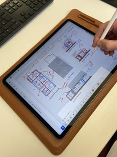 a person holding a pen and drawing on an ipad