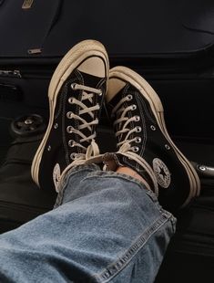 a person's feet resting on top of a piece of luggage with their shoes off