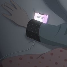 a person laying in bed with an alarm clock on their arm and the phone is plugged in