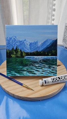 an acrylic painting is sitting on a table next to some paintbrushes