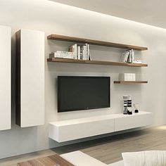 a modern living room with white furniture and bookshelves on the wall, along with a flat screen tv