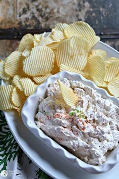 a white plate topped with chips and a bowl of dip