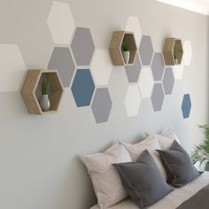 a bed sitting under a window next to a wall with hexagons on it