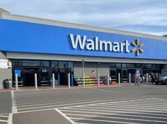 a walmart store with cars parked in the parking lot and people walking out front