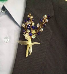 a boutonniere with blue and yellow flowers on it's lapel