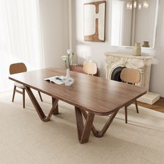 a wooden table sitting on top of a carpeted floor next to a fire place