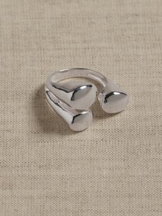 a silver ring sitting on top of a beige cloth