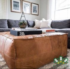 a brown leather ottoman with books on it