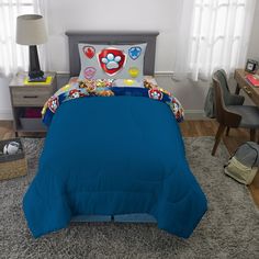 a bed with blue sheets and mario mouse comforter on it in a child's bedroom