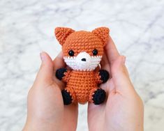 a hand holding a small crocheted stuffed animal