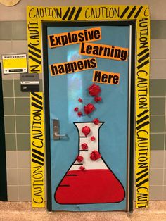 a classroom door decorated with red flowers and writing that says explosive learning happens here on it