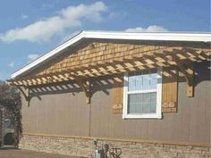 a house with a wooden pergolan attached to the roof and side of it