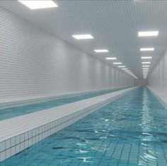 an empty swimming pool with blue tiles on the floor and water running down the wall