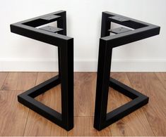 two black metal side tables sitting on top of a wooden floor