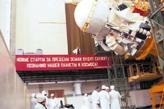 several men in white suits standing around a large object