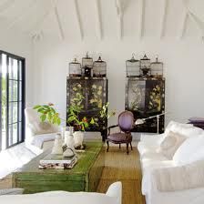 a living room filled with white furniture and lots of plants on top of the tables