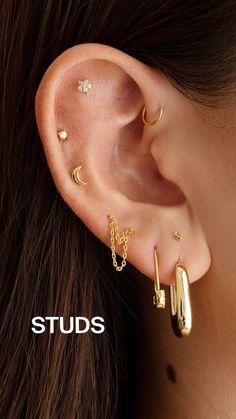 a woman wearing gold ear piercings with stars and moon designs