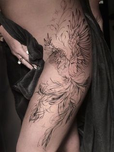 a woman's thigh with a tattoo design on her leg and an eagle in the middle