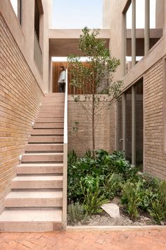 the stairs lead up to the upper level of this modern home, which has brick walls and stone steps