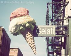 an ice cream cone hanging off the side of a building with a sign that says gelati