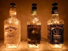 three bottles with lights in them sitting next to each other